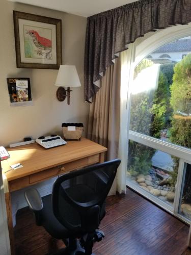 un ufficio con scrivania, finestra e sedia di Los Gatos Garden Inn Hotel a Los Gatos