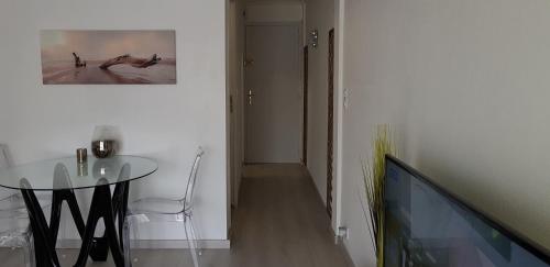 a dining room with a glass table and a picture on the wall at Palm beach Cannes Azur in Cannes