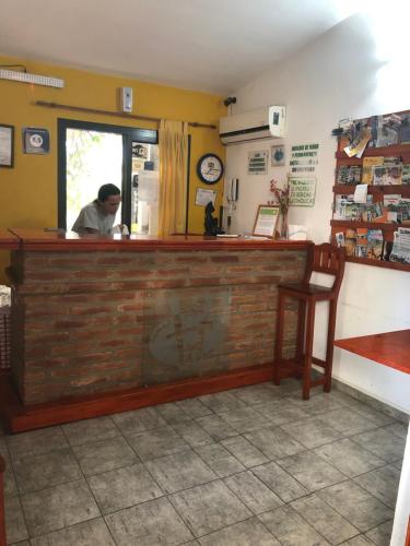 
a man sitting at a counter in a restaurant at Carlos Paz Hostel&Suites in Villa Carlos Paz
