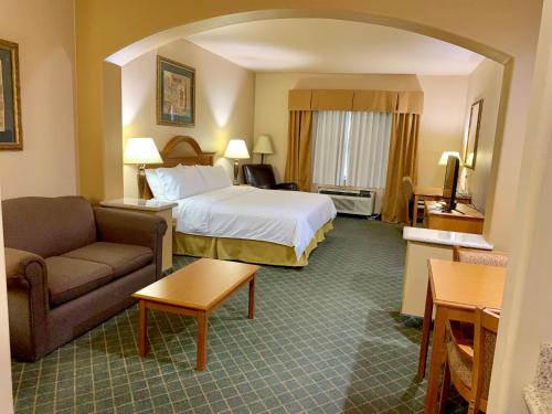 ein Hotelzimmer mit einem Bett und einem Sofa in der Unterkunft Holiday Inn Express Hotel and Suites Alice, an IHG Hotel in Alice