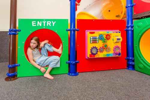 a young girl is sitting in a play room at NRMA Ballarat Holiday Park in Ballarat