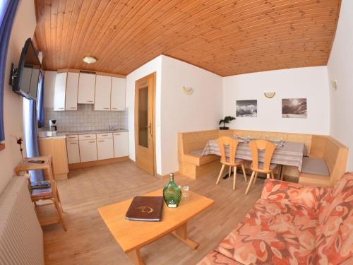 ein Wohnzimmer und eine Küche mit einem Tisch und Stühlen in der Unterkunft Haus Lena in Sulden