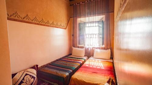 a small room with a bench in front of a window at Ecolodge l'île de Ouarzazate in Ouarzazate