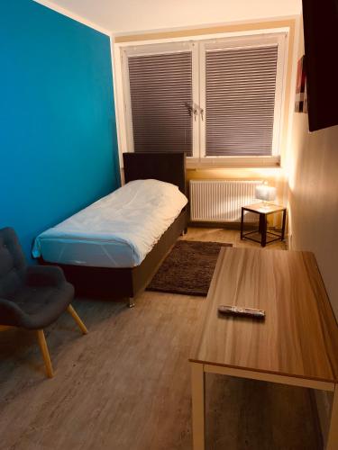 a small room with a bed and a table at White Pearl Hostel 1 in Nürnberg