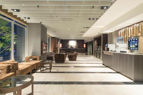 a lobby with couches and tables in a building at Hotel Forza Oita in Oita