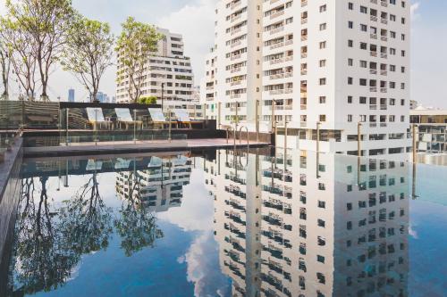 a reflection of buildings in a pool of water at Sukhumvit Asok Modern Suite in Bangkok