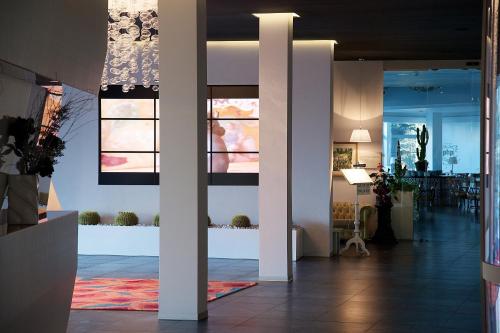 a lobby of a building with columns and plants at Plaza Hotel Abano Terme in Abano Terme