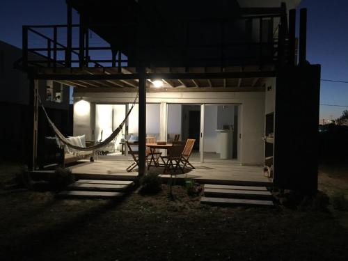 a house with a hammock on a patio at night at La Toscana 1 in Piriápolis