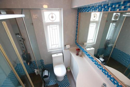 a small bathroom with a toilet and a mirror at Lantau Lodge in Hong Kong