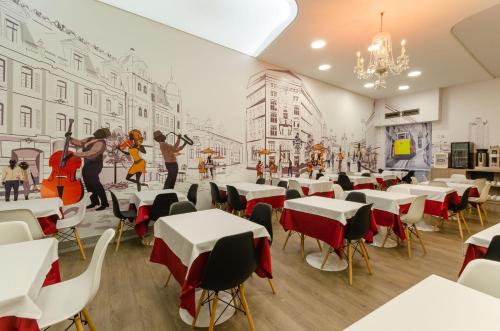 a restaurant with tables and chairs and a mural of a city at Hotel INN Rossio in Lisbon