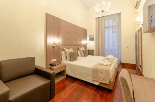 a bedroom with a bed and a chair at Hotel INN Rossio in Lisbon