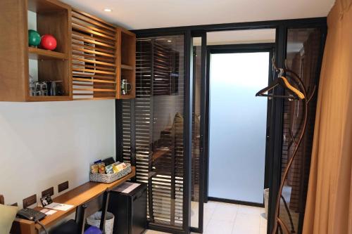 a room with a desk and a glass door at The Henry Hotel Manila in Manila