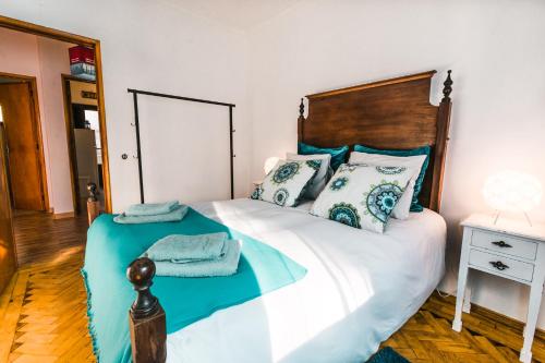 um quarto com uma cama com uma cabeceira e almofadas de madeira em Lisboa Manaia Home em Lisboa