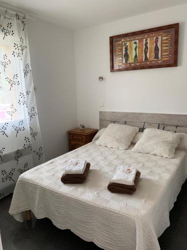 a bedroom with a bed with two towels on it at Appart'Hôtel Les Rochers in Auriol