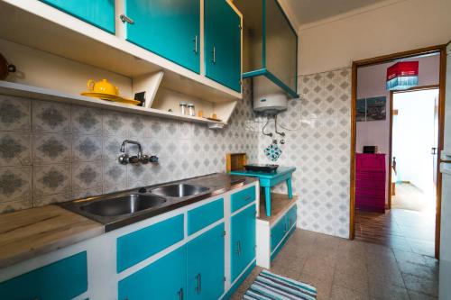 eine Küche mit blauen Schränken und einem Waschbecken in der Unterkunft Lisboa Manaia Home in Lissabon