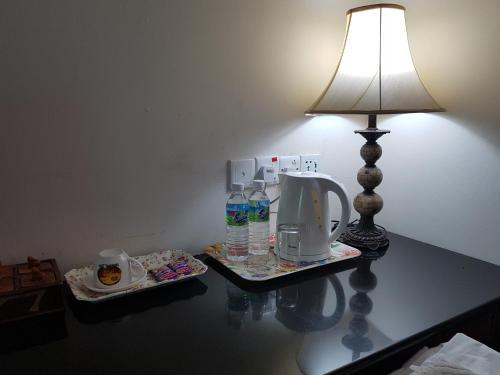 a table with a lamp and a coffee maker on it at Tokido Private Water Chalet PD in Port Dickson