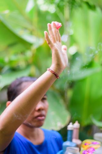 a woman holding her hand up in the air at Melali Bingin in Uluwatu