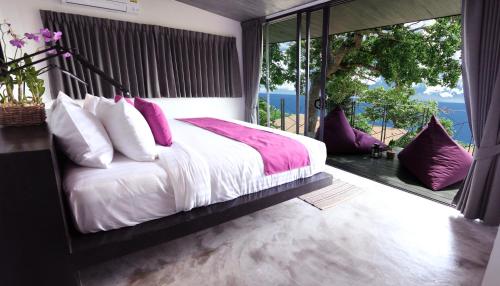a bedroom with a large bed and a large window at Pahili Pool Villas Koh Tao - SHA Plus in Koh Tao