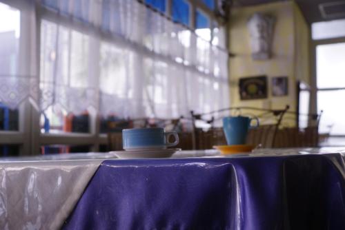 a table with two cups and a purple table cloth at 荷蘭洋行-寵物友善塩水燈會井仔腳塩田 in Xuejia