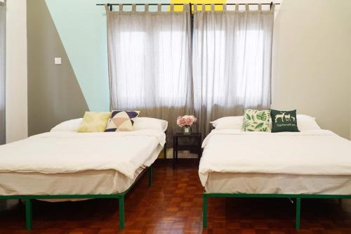 two beds in a room with a window at In Homs 26 in Klang