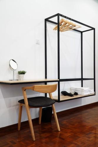 a desk with a wooden chair and a mirror at In Homs 26 in Klang