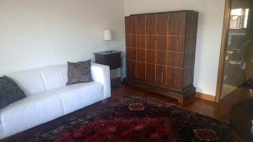 sala de estar con sofá blanco y armario de madera en Marginal Luminous Beach Apartment, en Vila do Conde