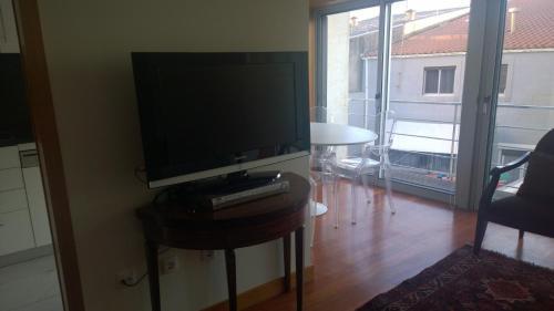 a television sitting on a table in a living room at Marginal Luminous Beach Apartment in Vila do Conde