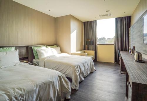 a hotel room with two beds and a window at Shu Xin Motel in Nantou City