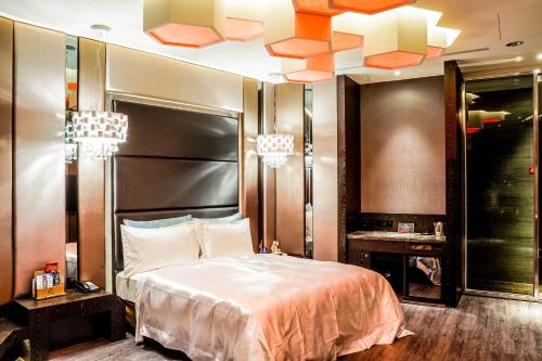 a bedroom with a large bed and chandeliers at Shu Xin Motel in Nantou City