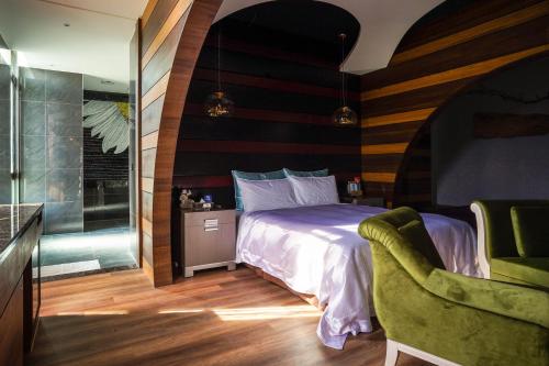 a bedroom with a bed and a chair at Shu Xin Motel in Nantou City