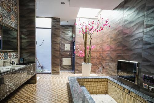 a bathroom with a vase with pink flowers in it at Shu Xin Motel in Nantou City