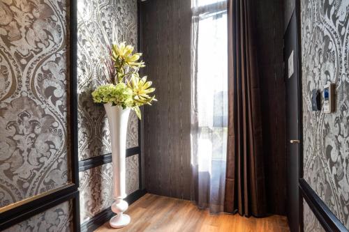 a vase of flowers in a hallway with a window at Shu Xin Motel in Nantou City