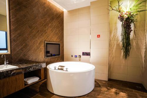 a bathroom with a tub and a sink at Shu Xin Motel in Nantou City
