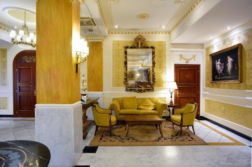 a living room with a yellow couch and chairs at Zanhotel Europa in Bologna