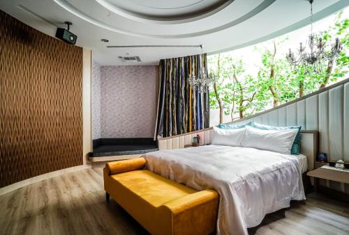a bedroom with a bed and a large window at Shu Xin Motel in Nantou City