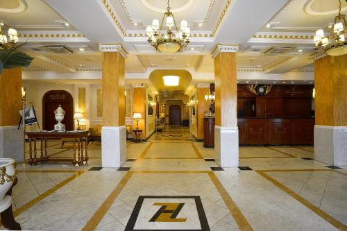 a lobby with columns and a chandelier in a building at Zanhotel Europa in Bologna