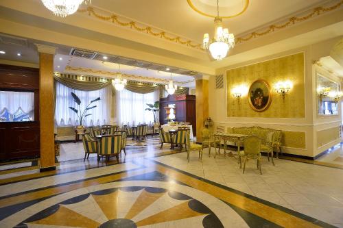 a lobby with a dining room with tables and chairs at Zanhotel Europa in Bologna
