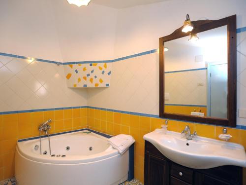 La salle de bains est pourvue d'une baignoire, d'un lavabo et d'un miroir. dans l'établissement Locanda Costa Diva, à Praiano
