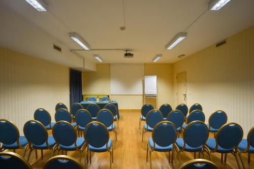 a conference room with blue chairs in it at Zanhotel Europa in Bologna