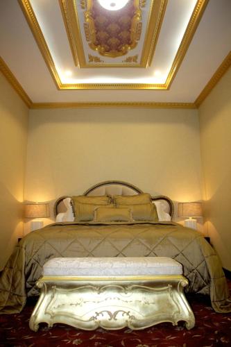 a bedroom with a bed with a gold ceiling at Hotel Grand Q Gorontalo in Gorontalo