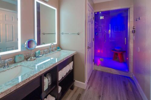 a bathroom with two sinks and a shower with purple lighting at Best Western Plus Humboldt Bay Inn in Eureka