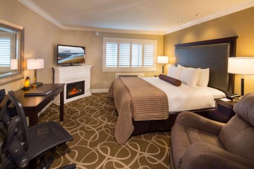 a hotel room with a bed and a desk and a fireplace at Best Western Plus Humboldt Bay Inn in Eureka