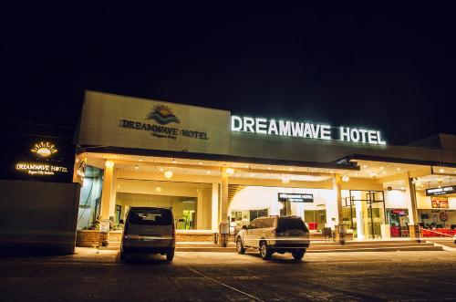 IlaganにあるDreamwave Hotel Ilaganの夢の膜ホテルの前に停められた2台の車