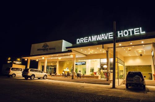 IlaganにあるDreamwave Hotel Ilaganの夜間に外に駐車した車を持つ夢のホテルです