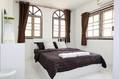 a bedroom with a large bed with two windows at Chatuchak Art & Nature House ( 3-6 pers.) in Bangkok
