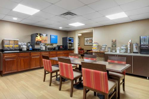 a dining room with tables and chairs and a kitchen at Comfort Inn & Suites Hamilton Place in Chattanooga
