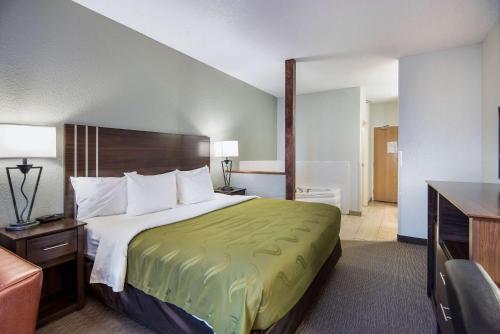 Un pat sau paturi într-o cameră la Quality Inn & Suites West