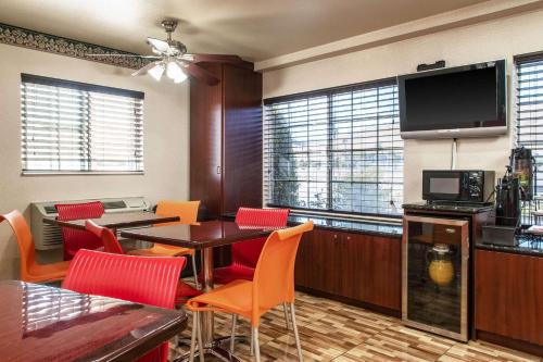 een restaurant met een tafel en stoelen en een televisie bij Executive Inn westley,CA in Westley