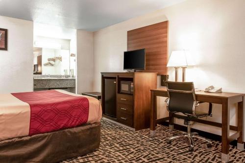 a hotel room with a bed and a desk with a computer at Executive Inn westley,CA in Westley