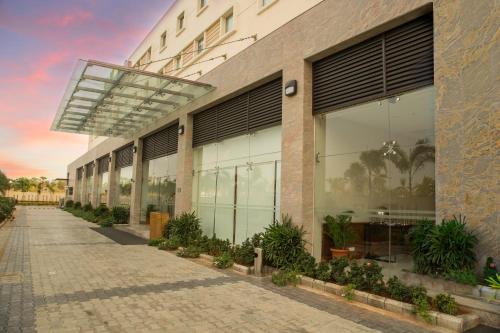 a building with large windows and plants in front of it at Kalyan Grand - a business hotel in Vandalūr
